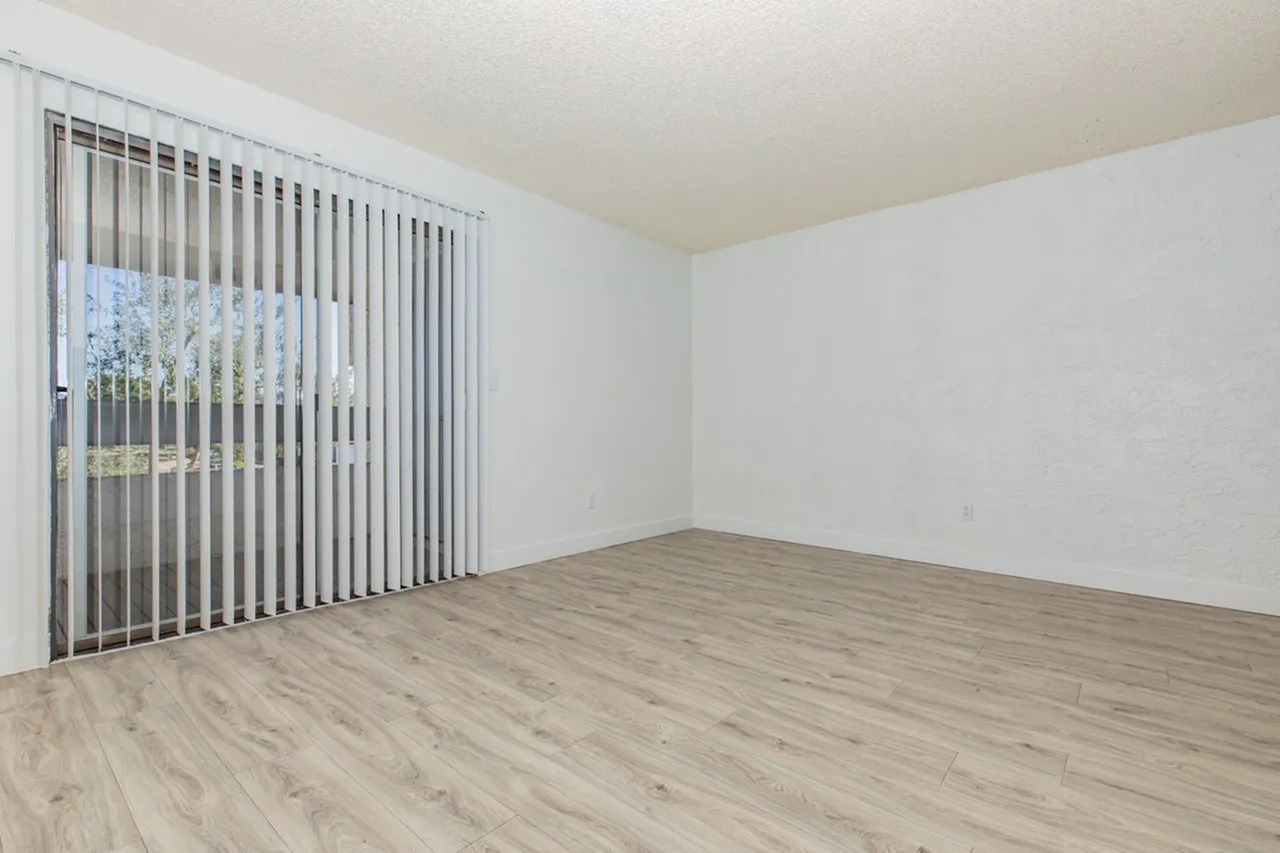 Bedroom, wood-style plank flooring, vertical blinds, white walls, glass door