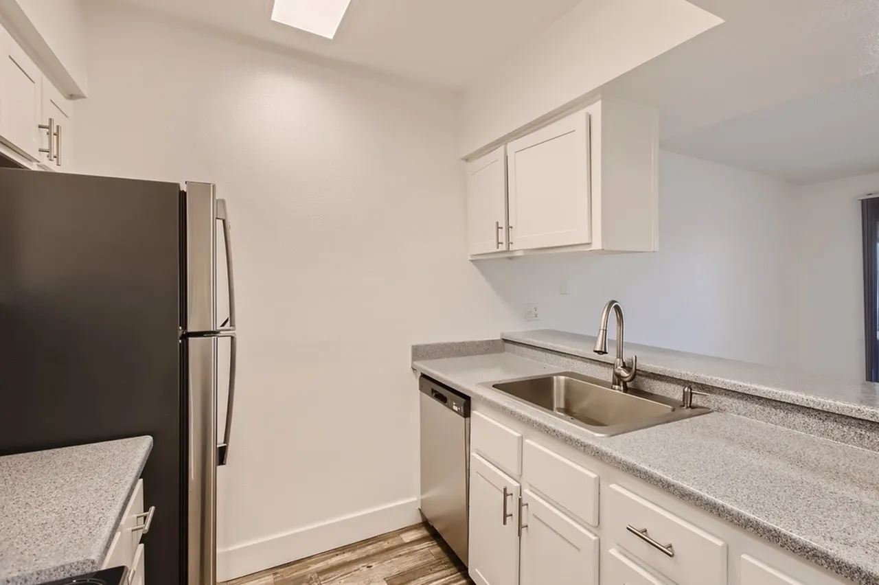 Kitchen, white shaker cabinetry, gray quartz countertops, stainless steel appliances, wood-style plank flooring
