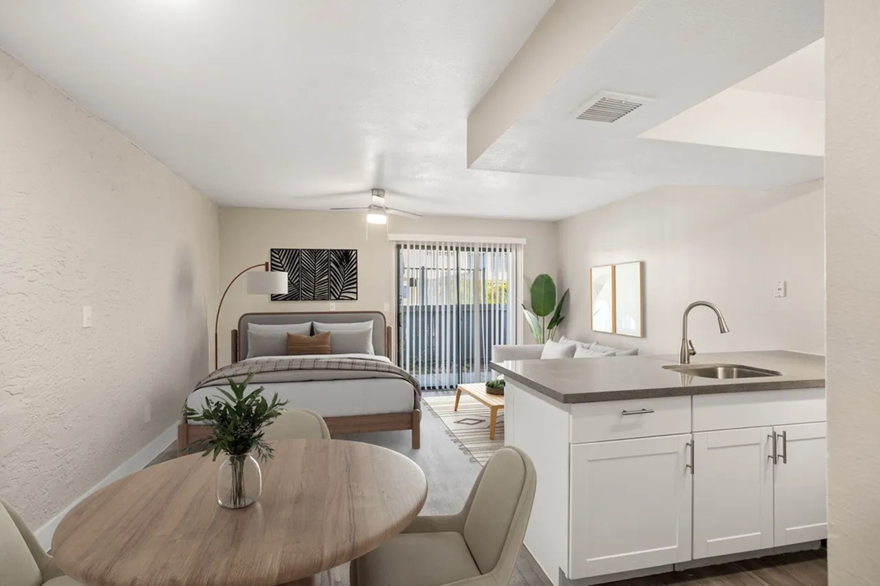 Studio interior, white cabinetry, quartz countertops, wood-style plank flooring, ceiling fan