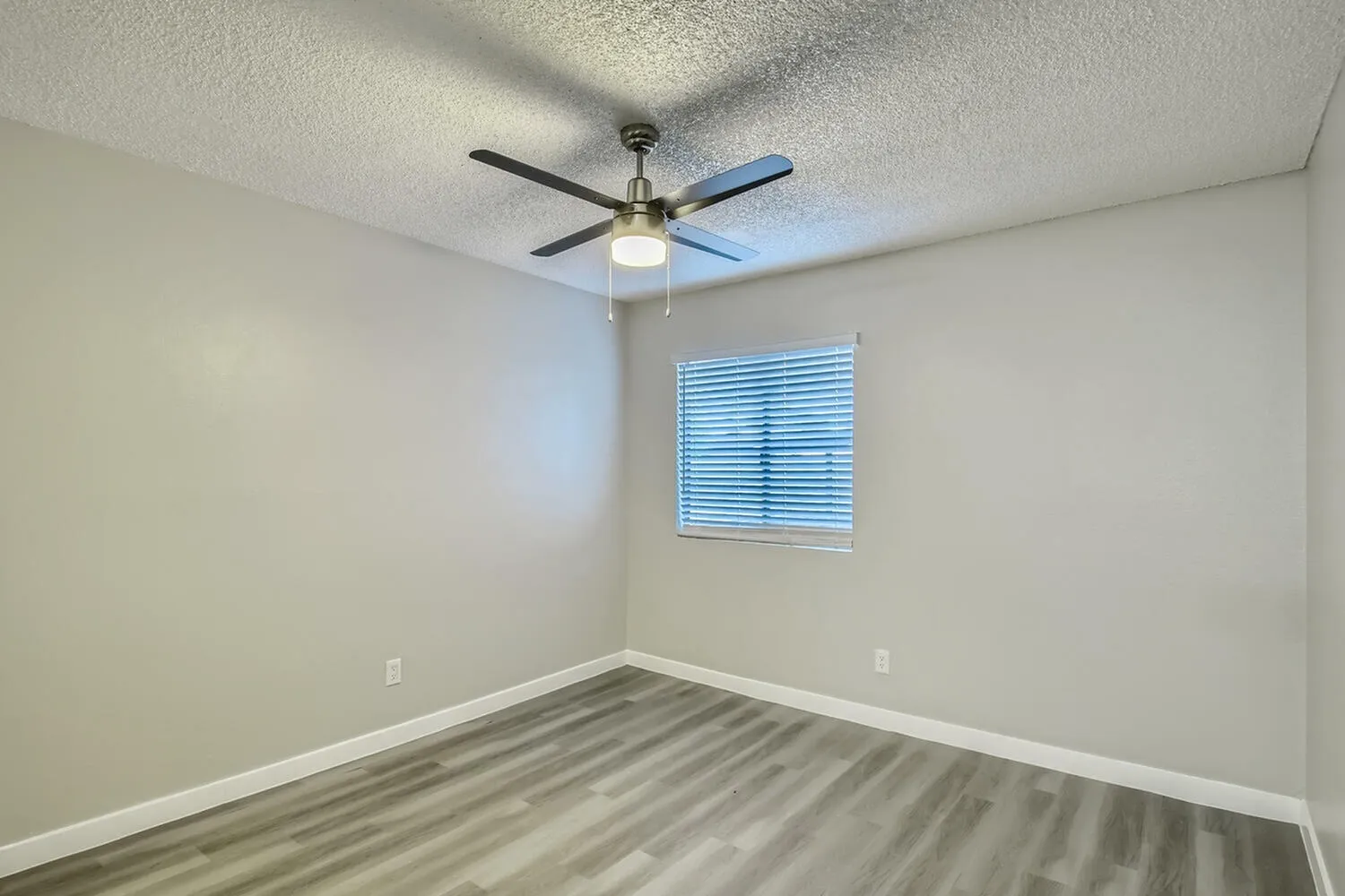 Bedroom, wood-style plank flooring, ceiling fan with light, window with blinds