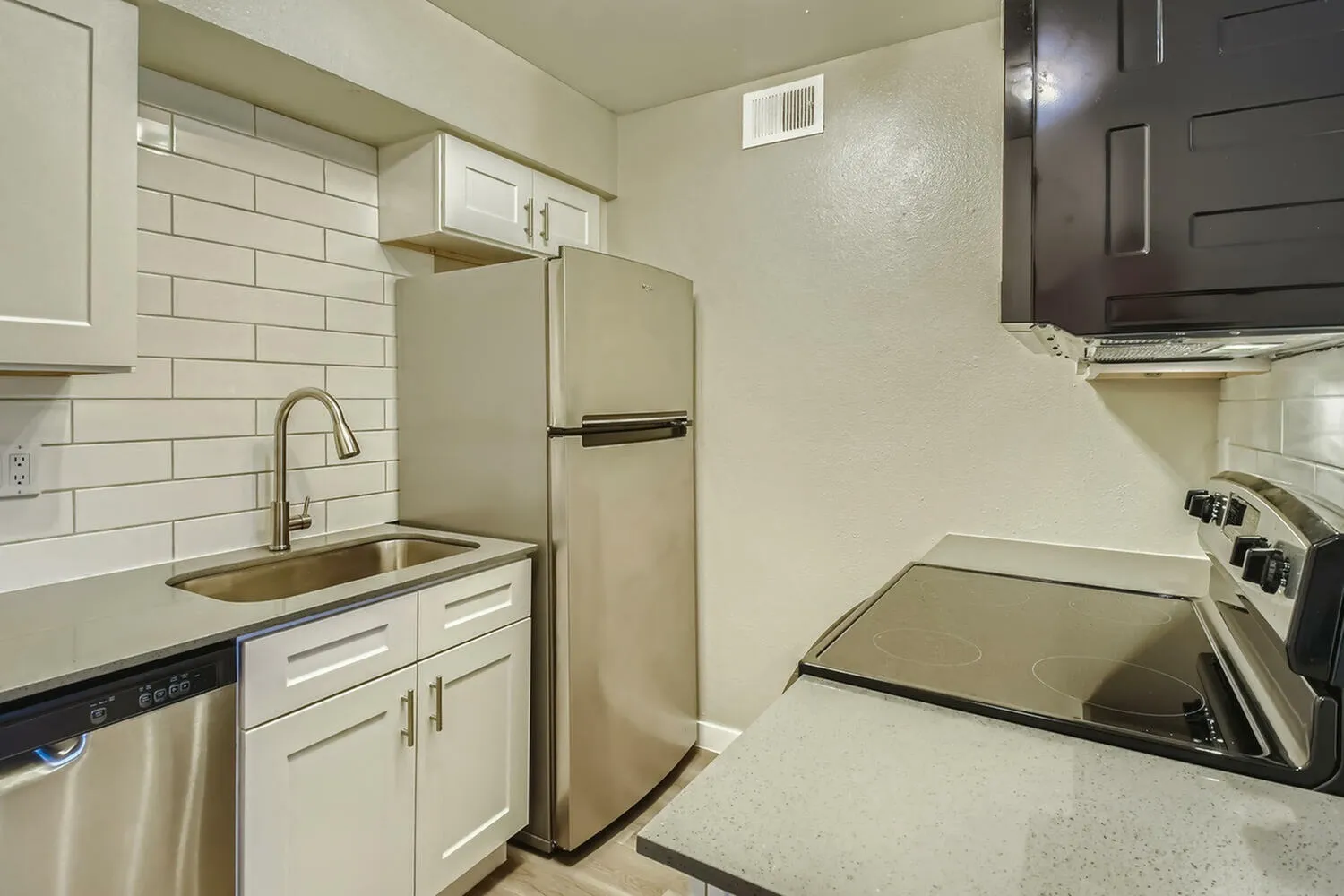 Kitchen, white shaker cabinetry, subway tile backsplash, stainless appliances, quartz countertops