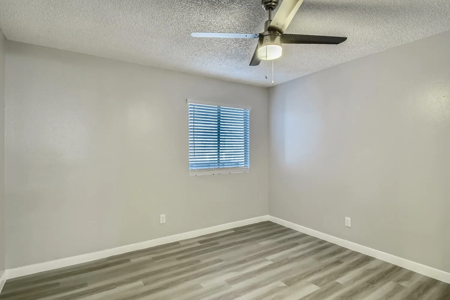 Bedroom, wood-style plank flooring, ceiling fan, blue shuttered window