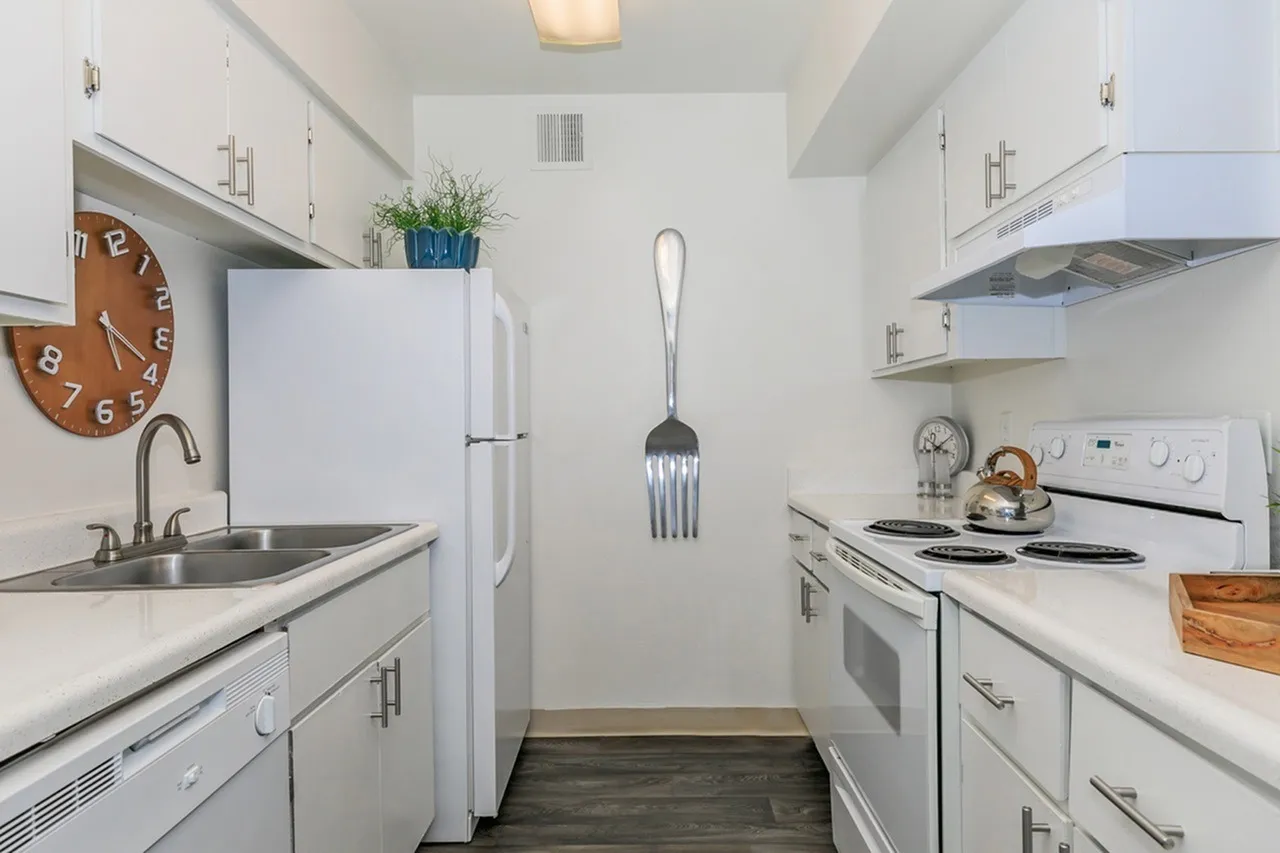 Kitchen, white shaker cabinetry, stainless sink, wood-style plank flooring, white appliances