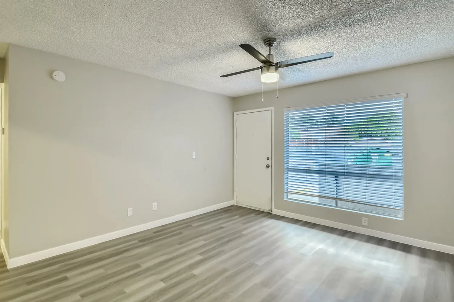 Bedroom, wood-style plank flooring, ceiling fan with light, glass sliding door with blinds