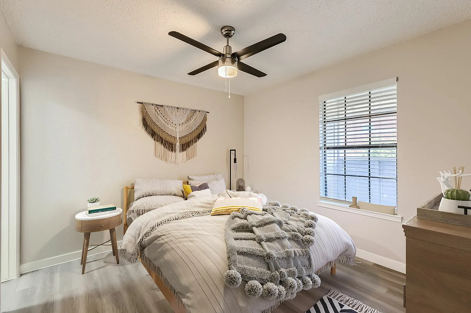 Primary bedroom, wood-style plank flooring, ceiling fan with light fixture, shutters on window