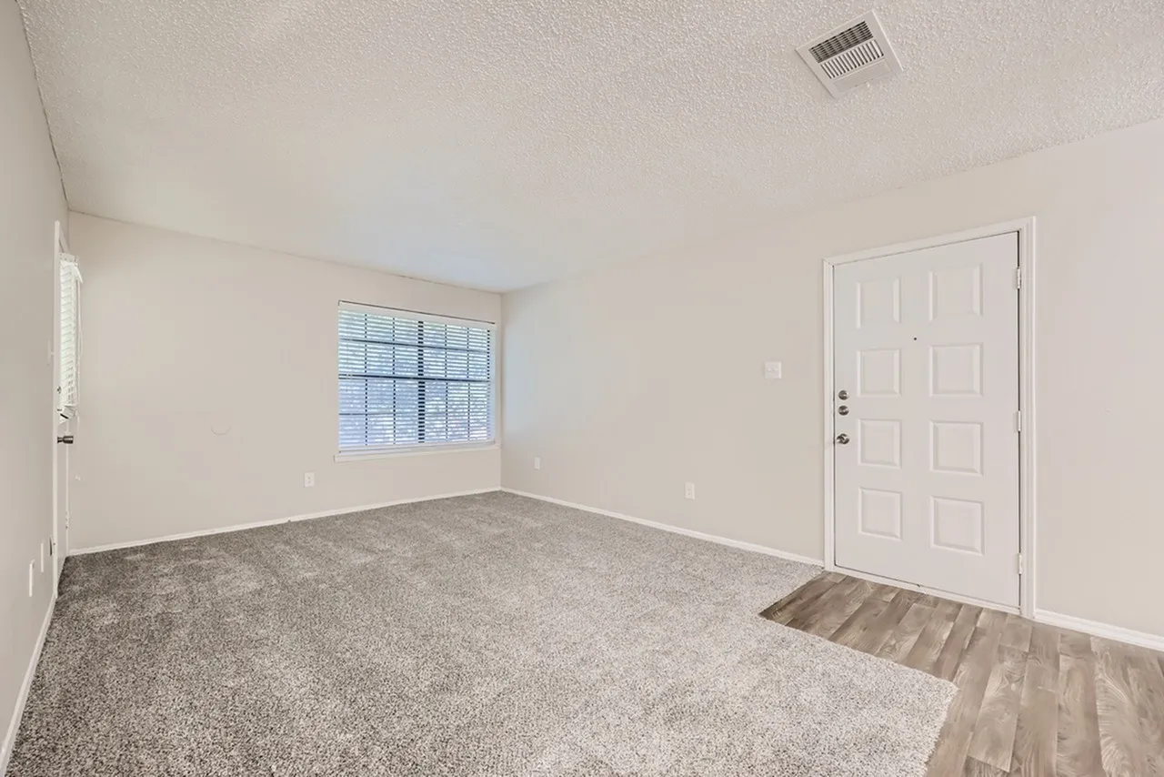 Bedroom, gray carpet flooring, white six-panel entry door, window with blinds