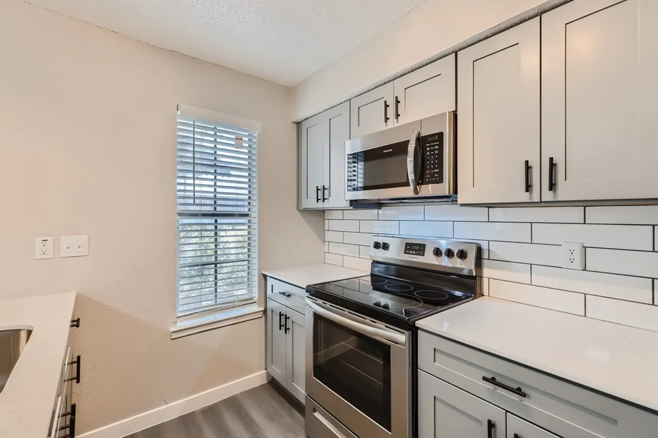 Kitchen, white shaker cabinetry, subway tile backsplash, stainless appliances, wood-style plank flooring