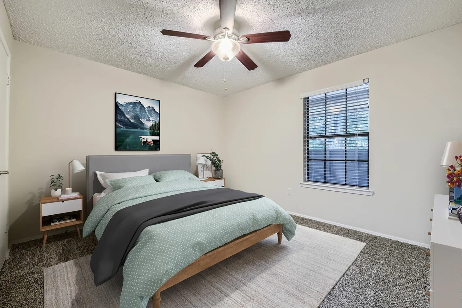 Primary bedroom, gray upholstered headboard, wood-style plank flooring, ceiling fan with light, window with blue shutters