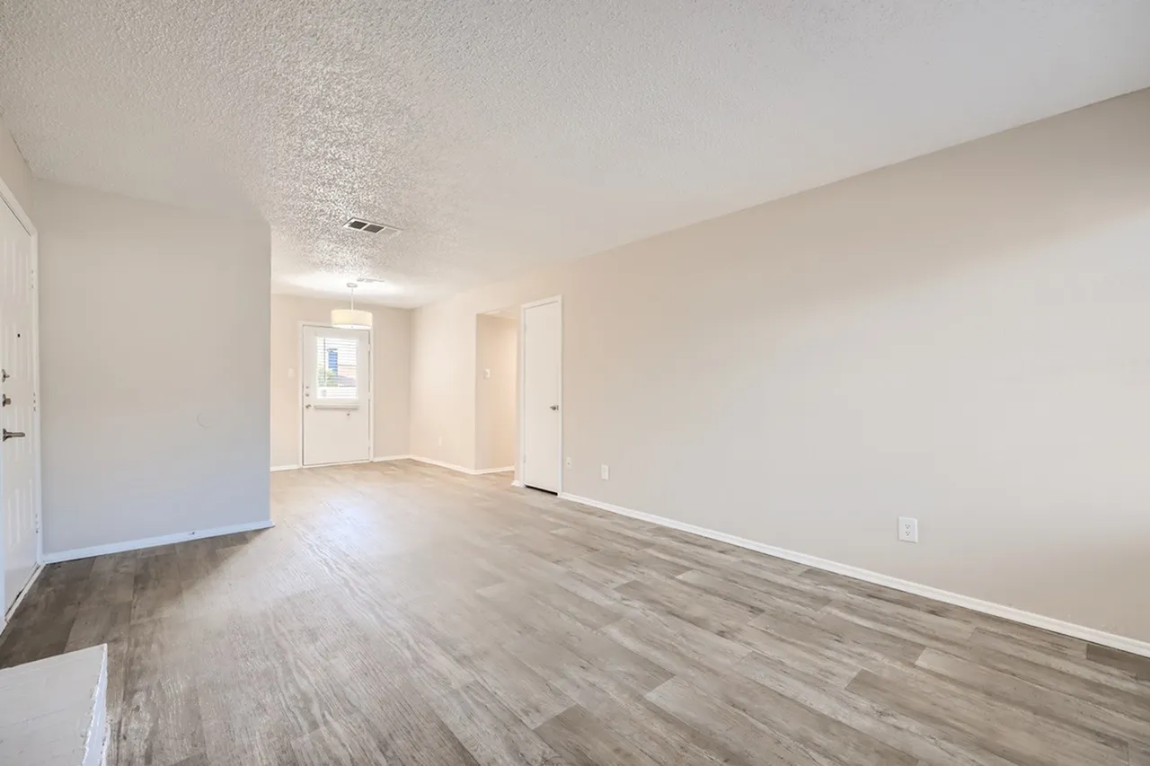 Living area, wood-style plank flooring, open layout, recessed lighting, white walls