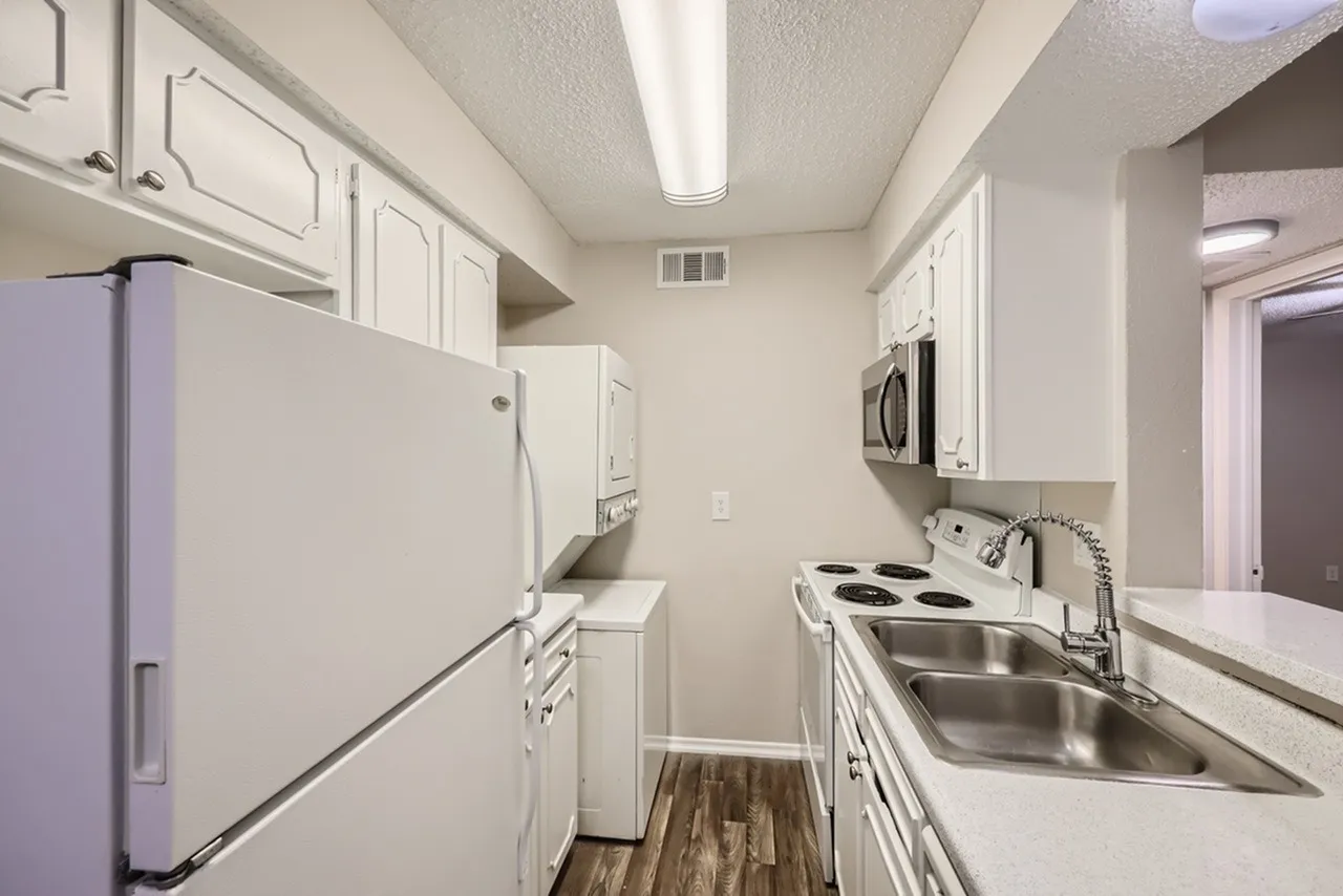Kitchen, white shaker cabinetry, stainless steel sink, electric range, wood-style plank flooring
