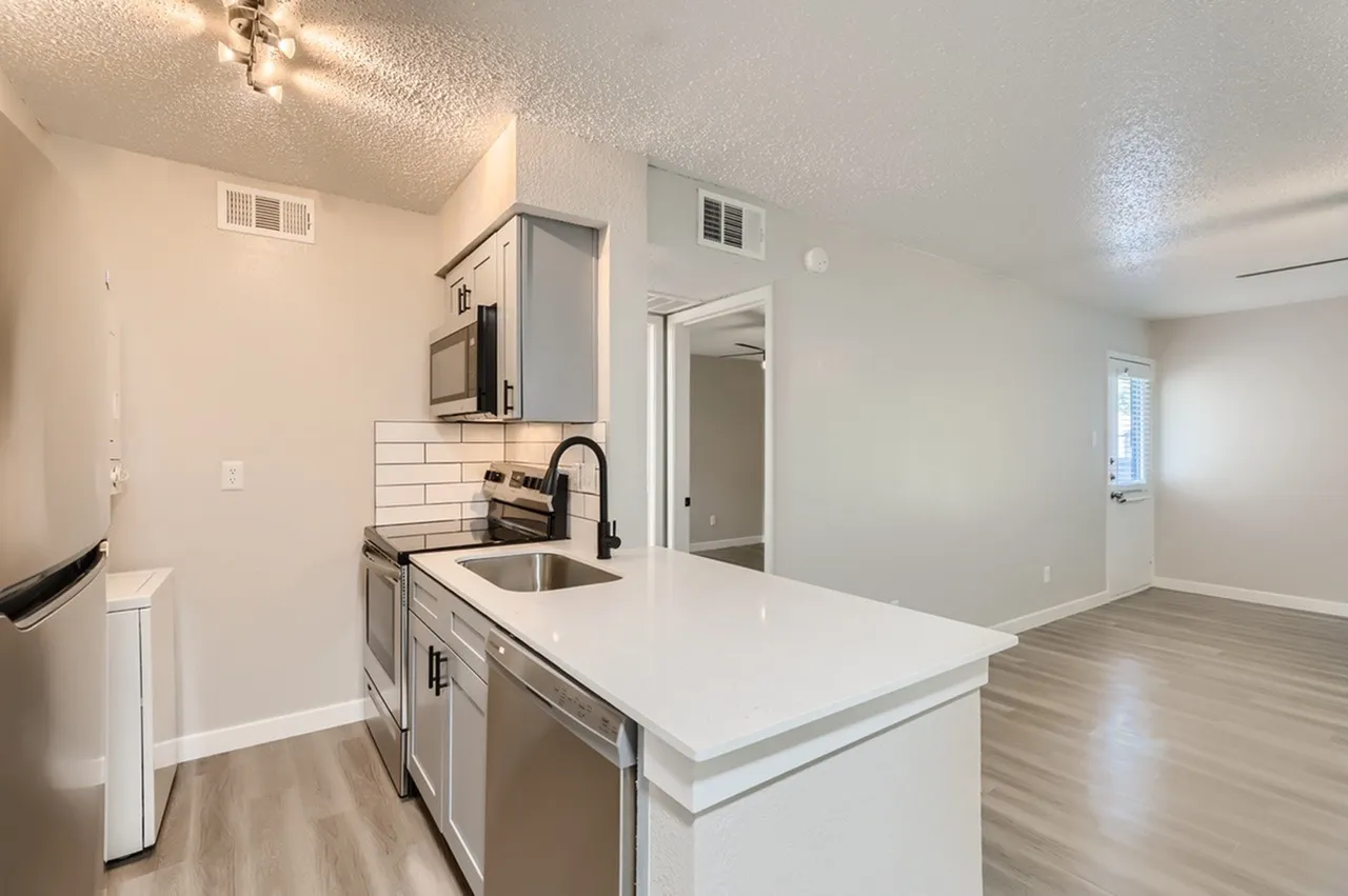 Kitchen, white quartz countertops, stainless steel appliances, subway tile backsplash, wood-style plank flooring