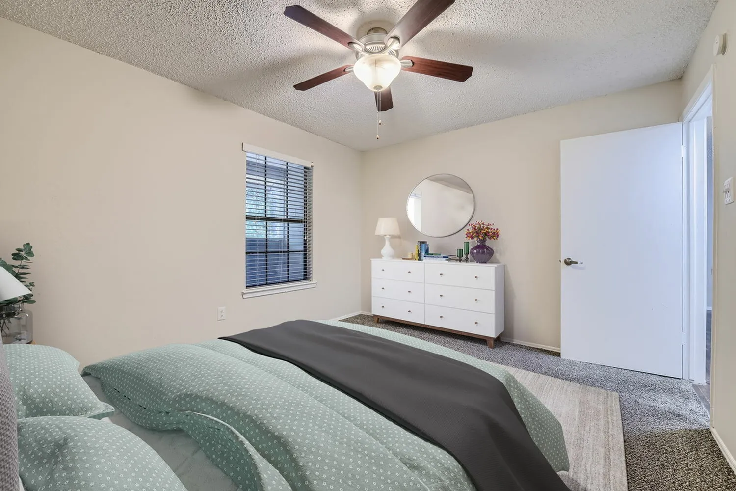 Primary bedroom, wood-style plank flooring, white dresser, ceiling fan, window
