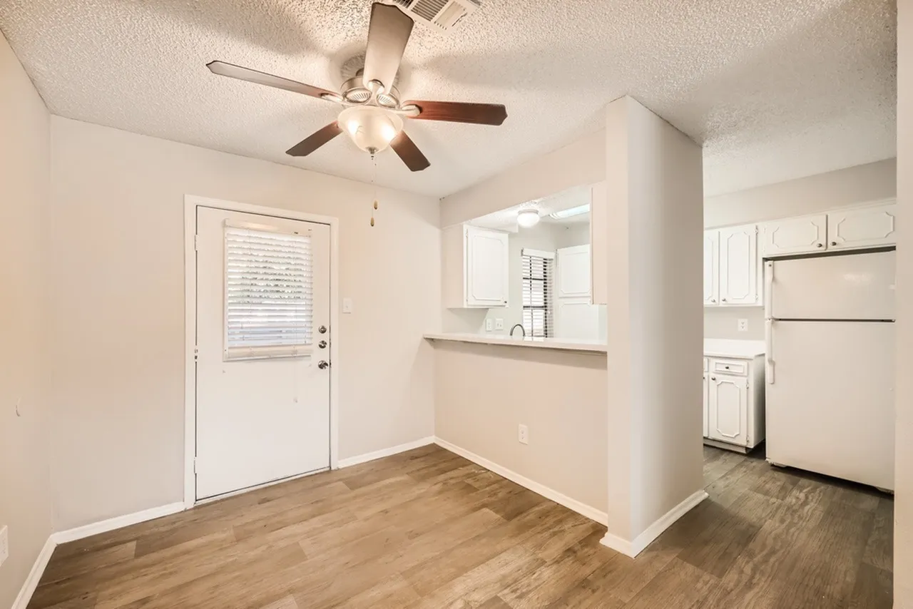 Kitchen and dining area, wood-style plank flooring, stainless steel appliances, ceiling fan with light