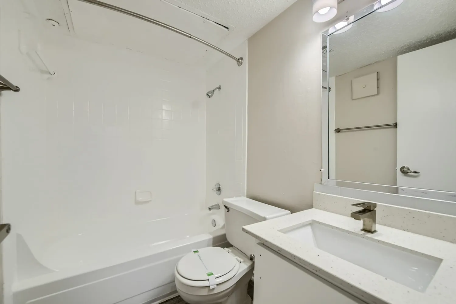 Bathroom, white vanity sink, large mirror, white subway tile surround, chrome fixtures