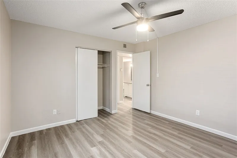 Bedroom with sliding closet doors and ceiling fan
