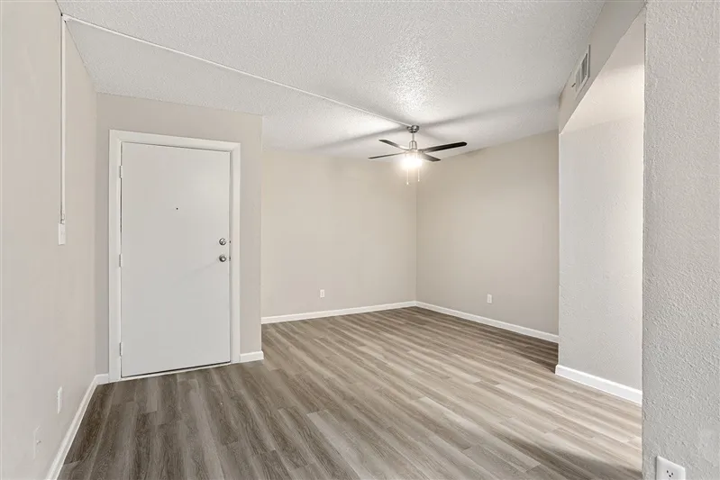 Living room with entry door and ceiling fan