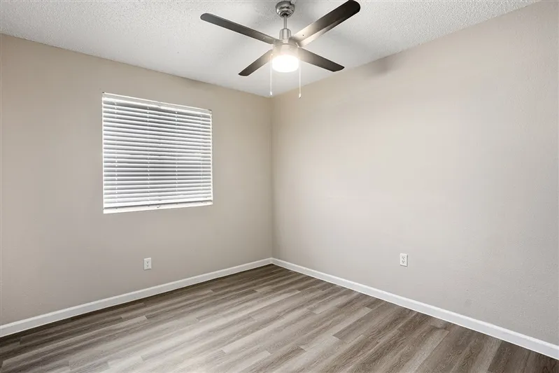 Bedroom with ceiling fan and window with blinds
