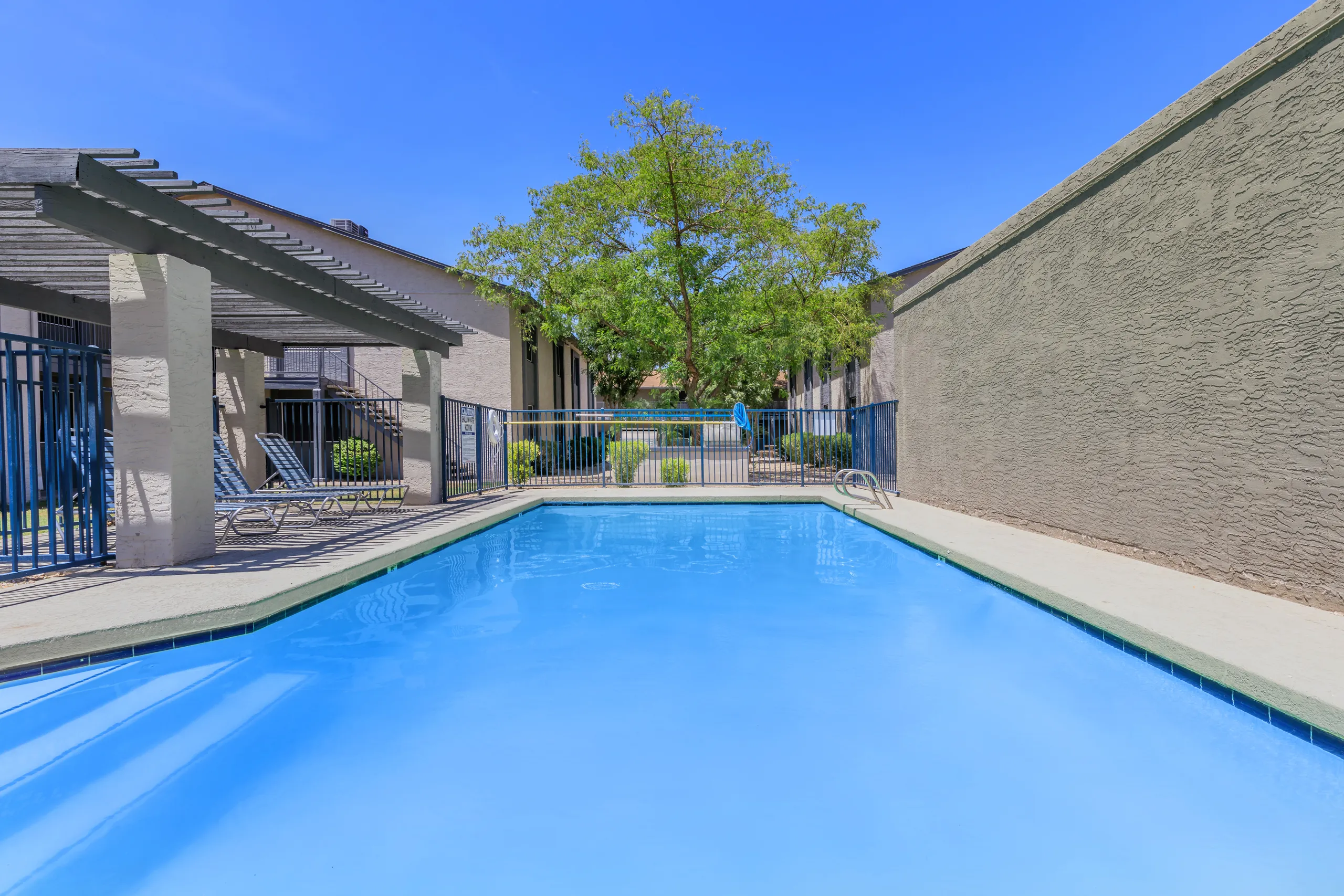 Community pool with covered seating and lounge chairs