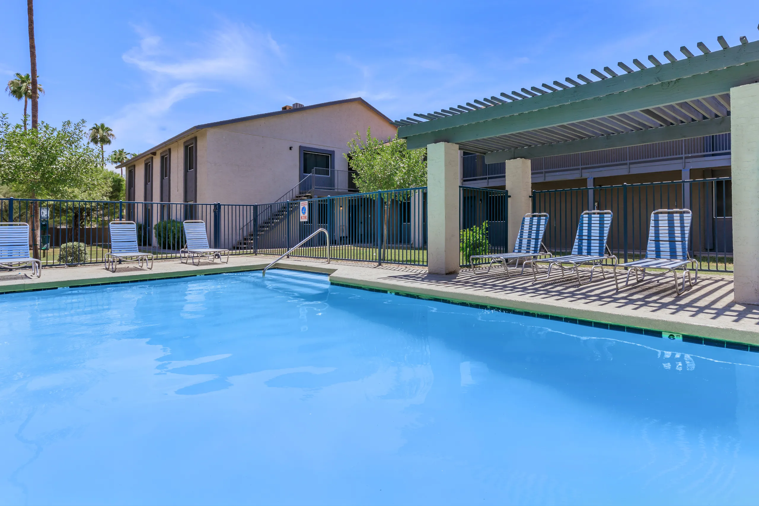 Community pool with covered pergola and lounge seating