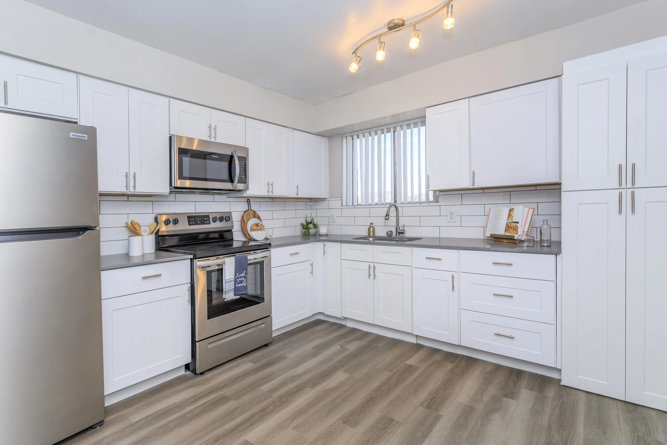 Renovated kitchen with white cabinetry and stainless steel appliances