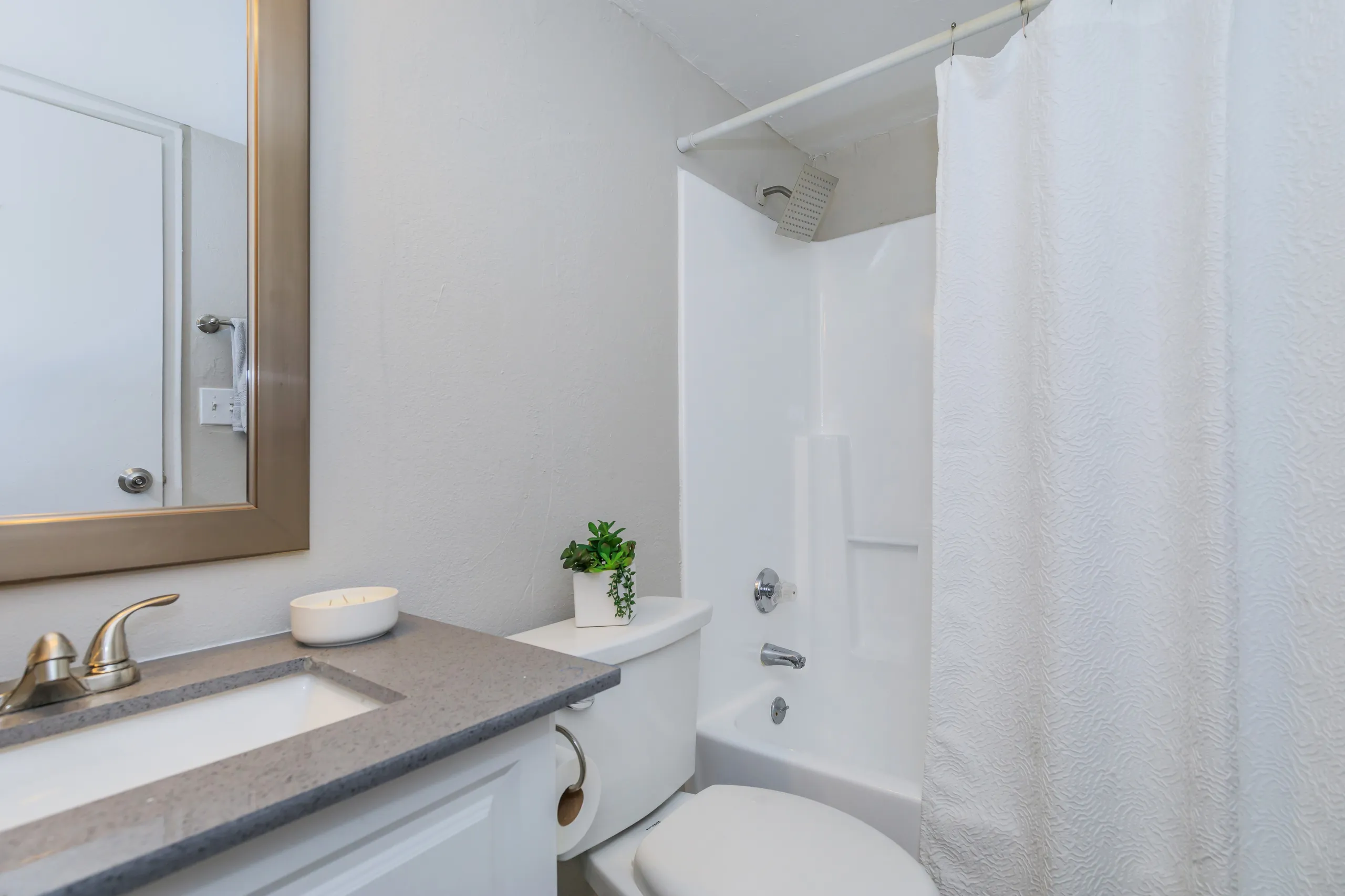 Updated bathroom with granite-style vanity and shower/tub combo