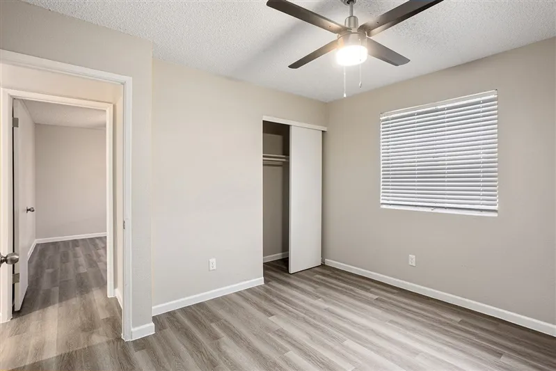 Bedroom with sliding closet doors and hallway view