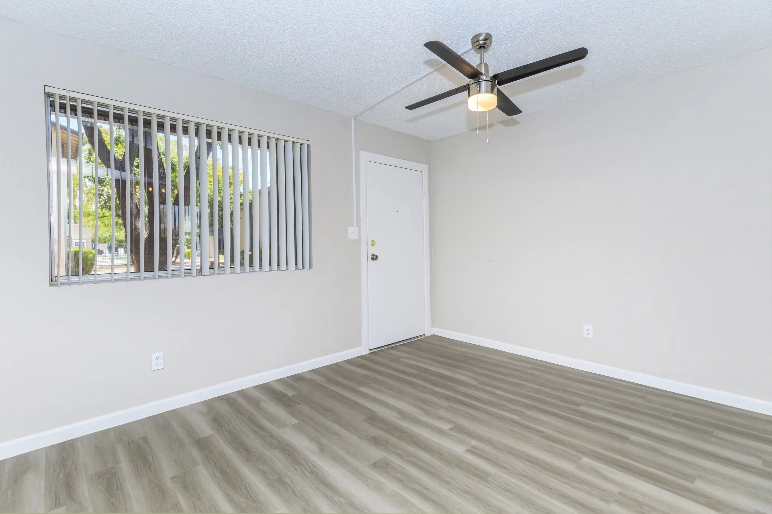 Living room with vertical blinds, ceiling fan, and entry door