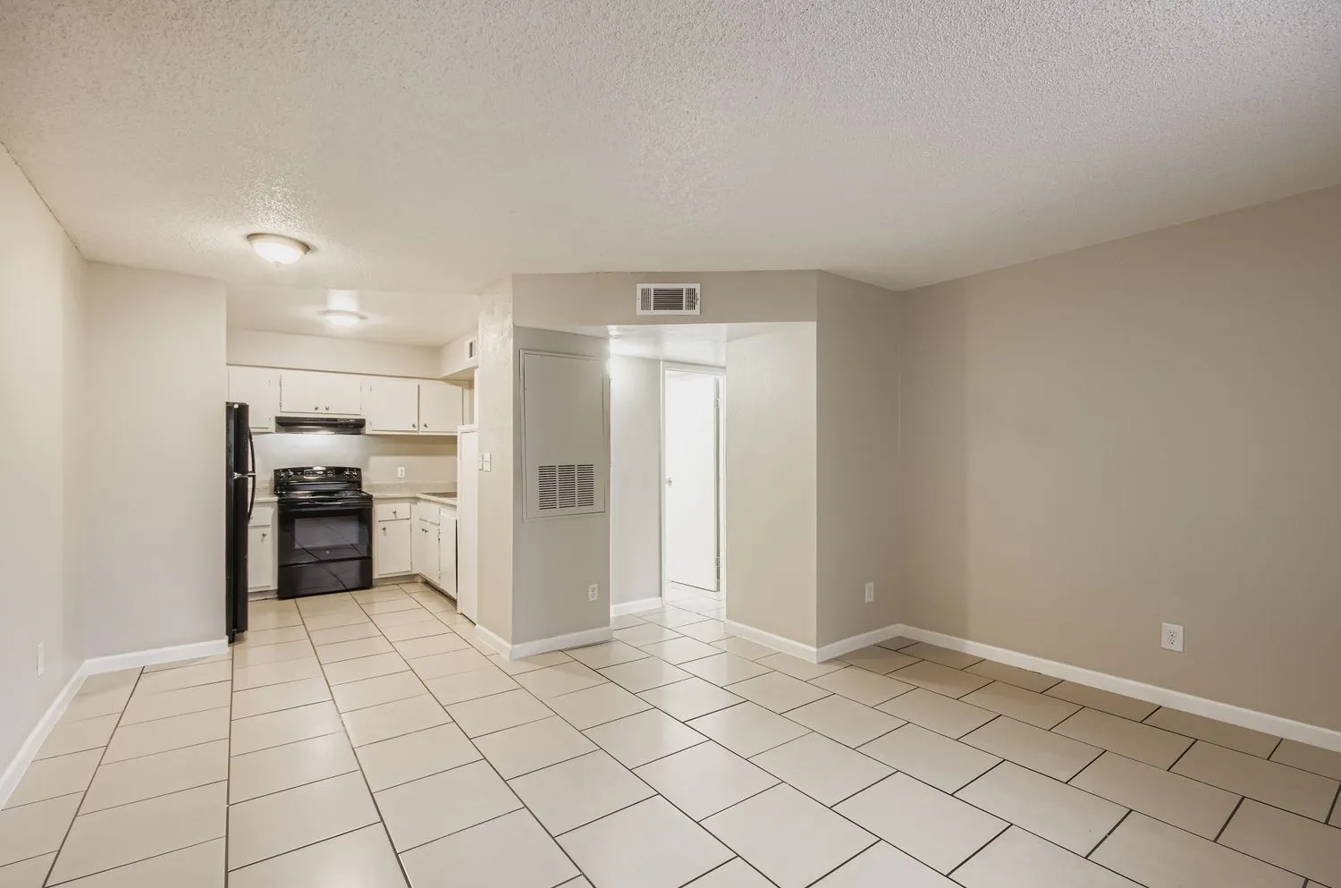 Open living area with view into kitchen and hallway
