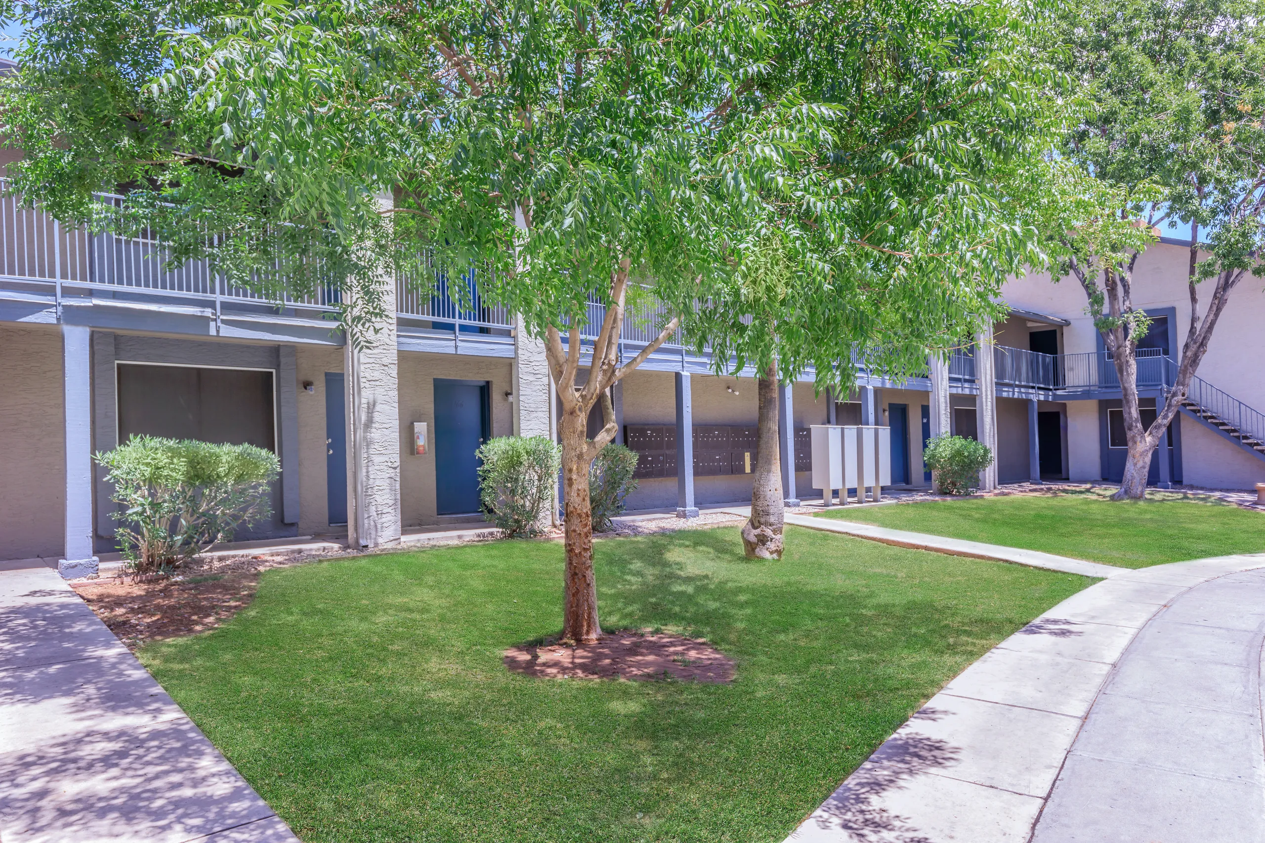 Shaded courtyard area with mailboxes and walking paths