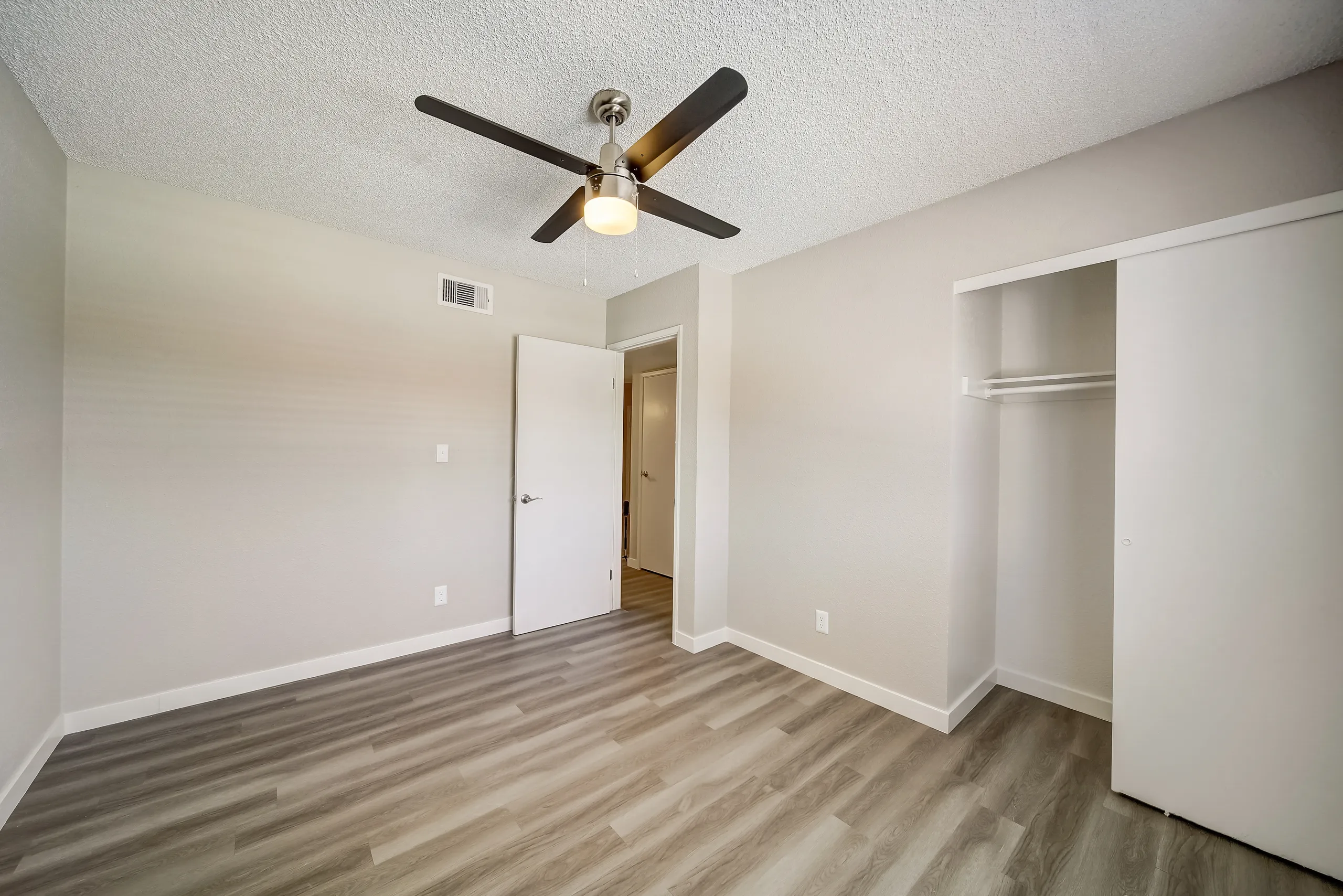 Bedroom with ceiling fan and sliding closet doors