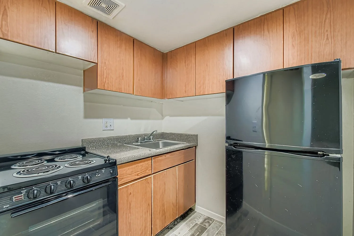 Kitchen, wood cabinetry, granite countertops, black gas range, black refrigerator