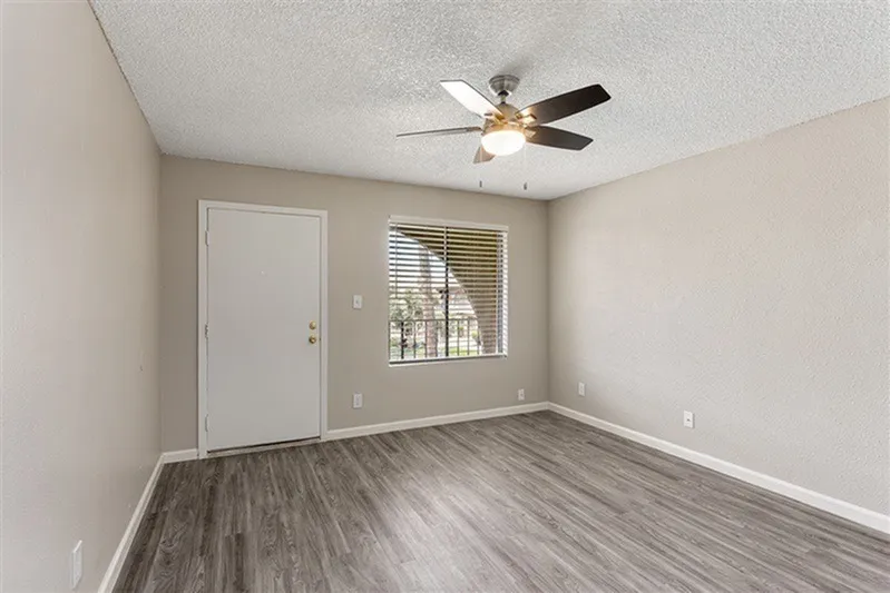 Bedroom, wood-style plank flooring, ceiling fan with lights, entry door, blinds at window