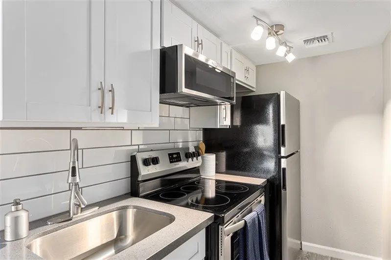 Kitchen, white shaker cabinetry, subway tile backsplash, stainless steel appliances, quartz countertops, stainless sink