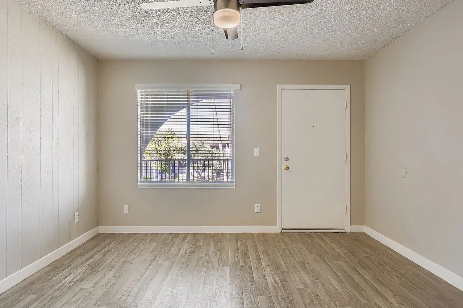 Bedroom, wood-style plank flooring, window with blinds, ceiling fan, entry door