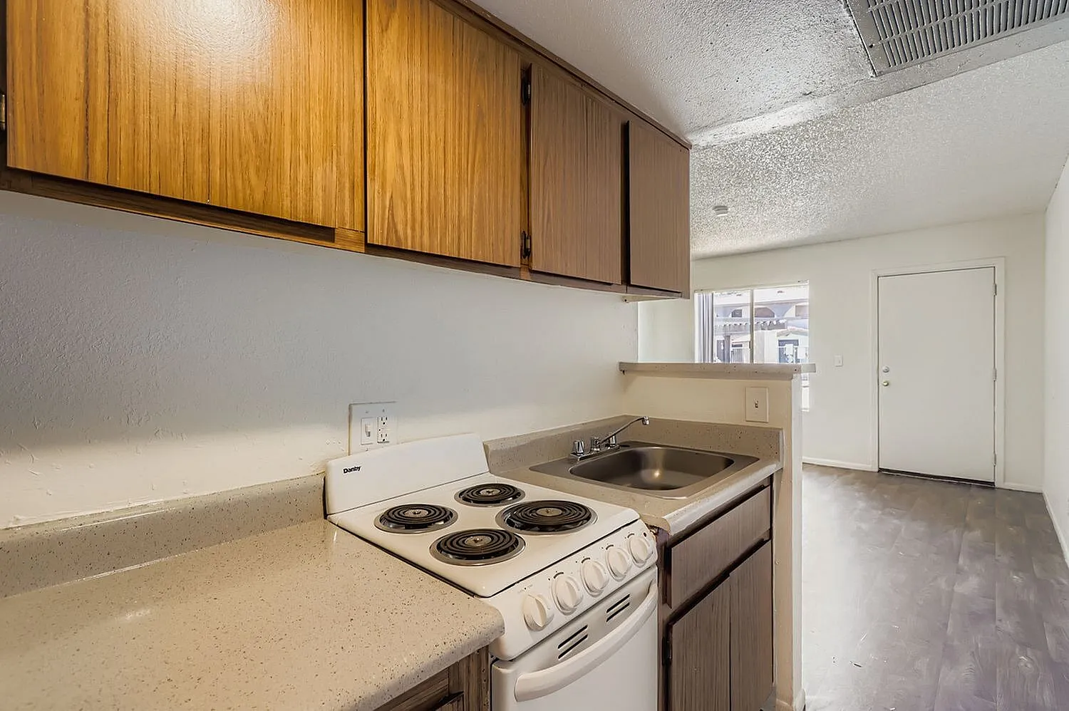 Kitchen, wood-grain upper cabinetry, laminate countertops, coil electric range, sink, wood-style plank flooring
