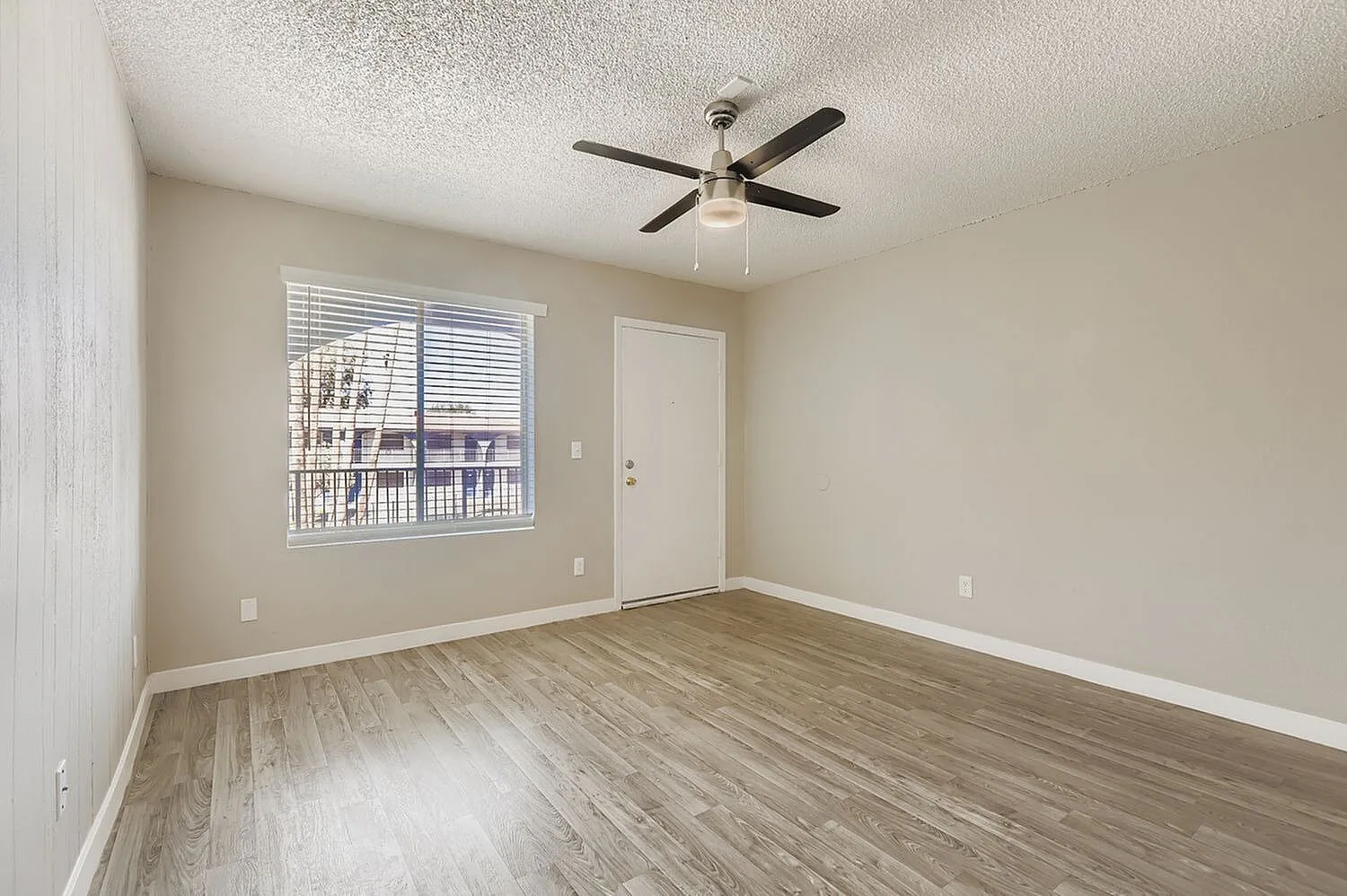 Bedroom, wood-style plank flooring, ceiling fan, sliding glass door with blinds, neutral walls