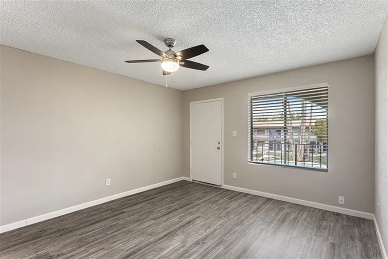Bedroom, wood-style plank flooring, ceiling fan with light, sliding window with blinds