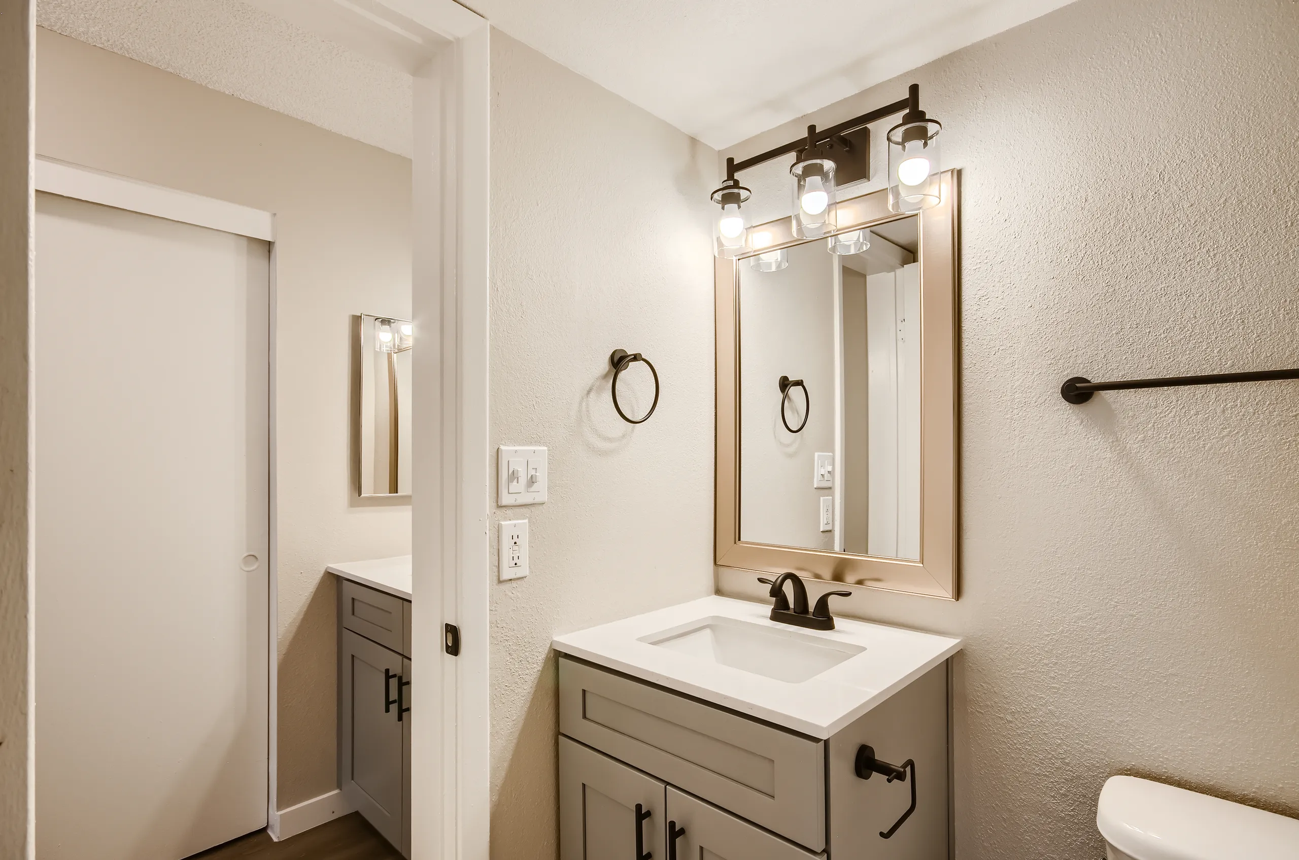 Bathroom, gray vanity cabinet, quartz countertop, framed mirror