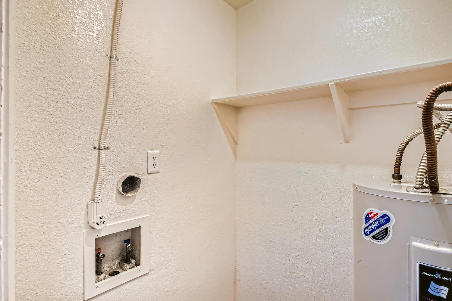 Laundry hookups, water heater, upper storage shelving