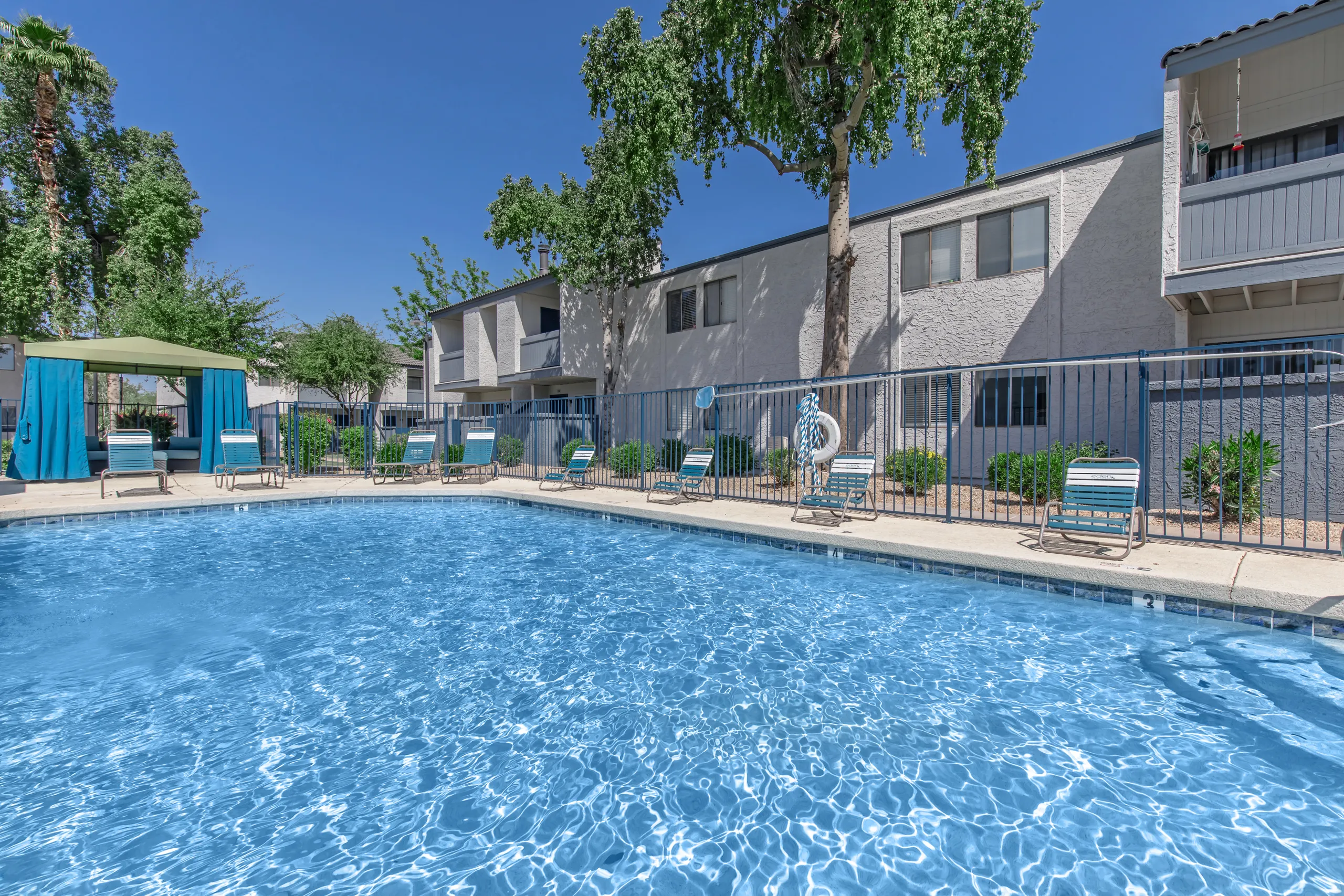 Community pool, lounge chairs, cabana seating, poolside landscaping