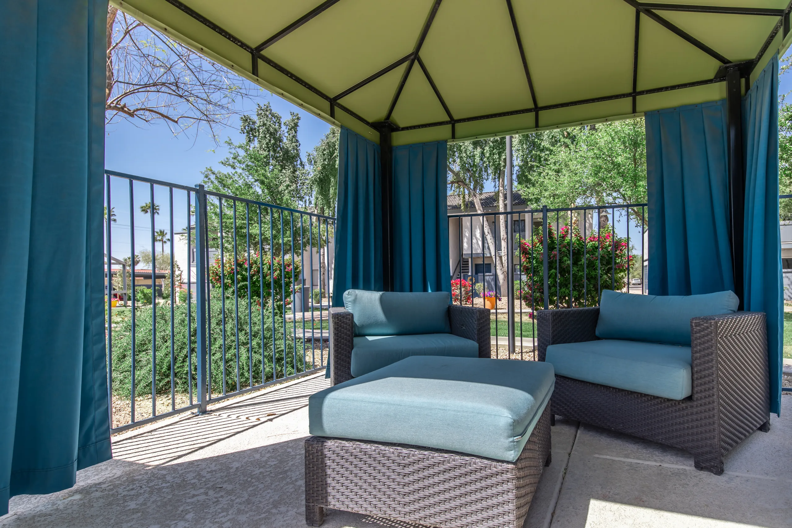 Covered cabana lounge, outdoor seating, poolside landscaping