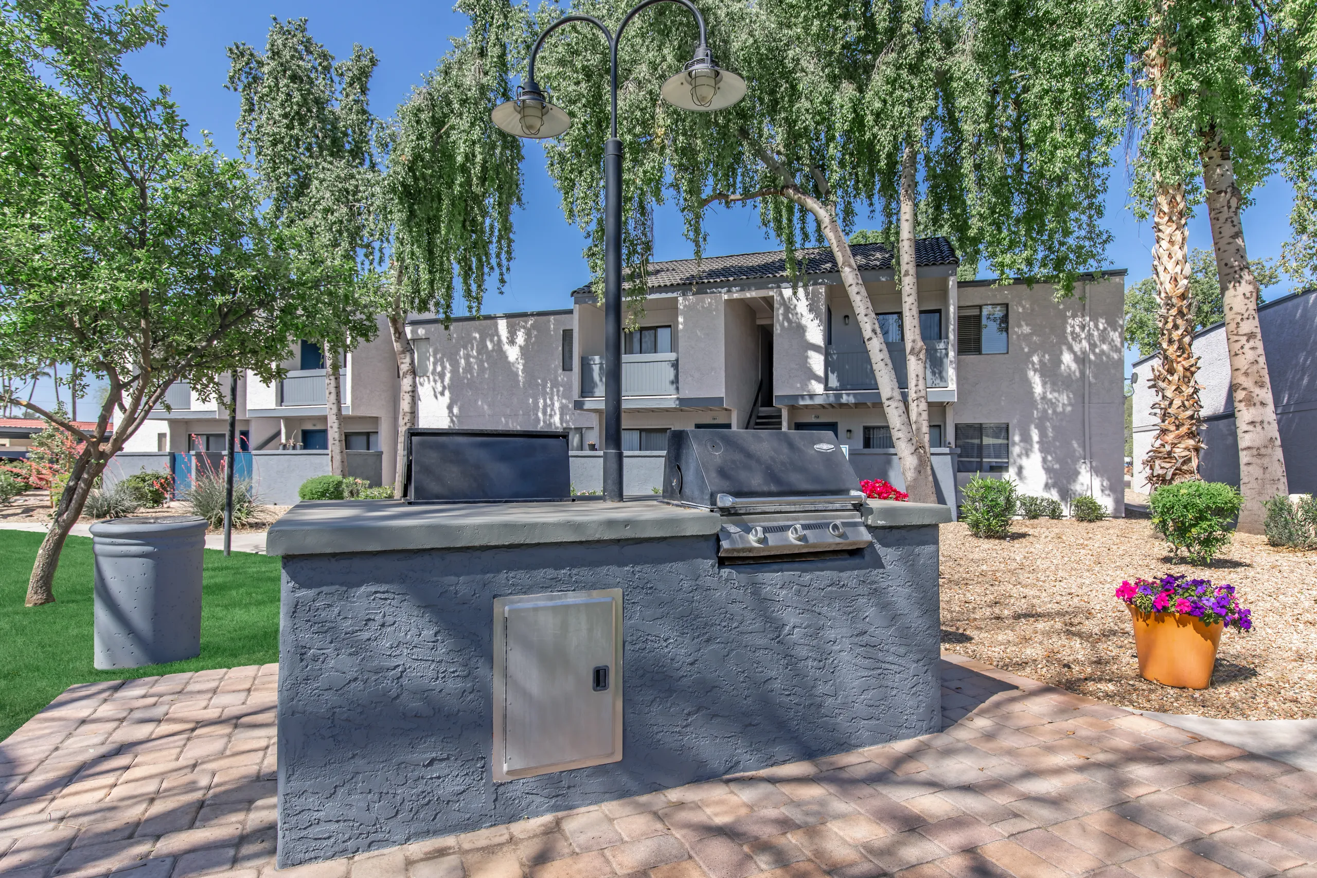 Community grill station, outdoor seating, shaded courtyard