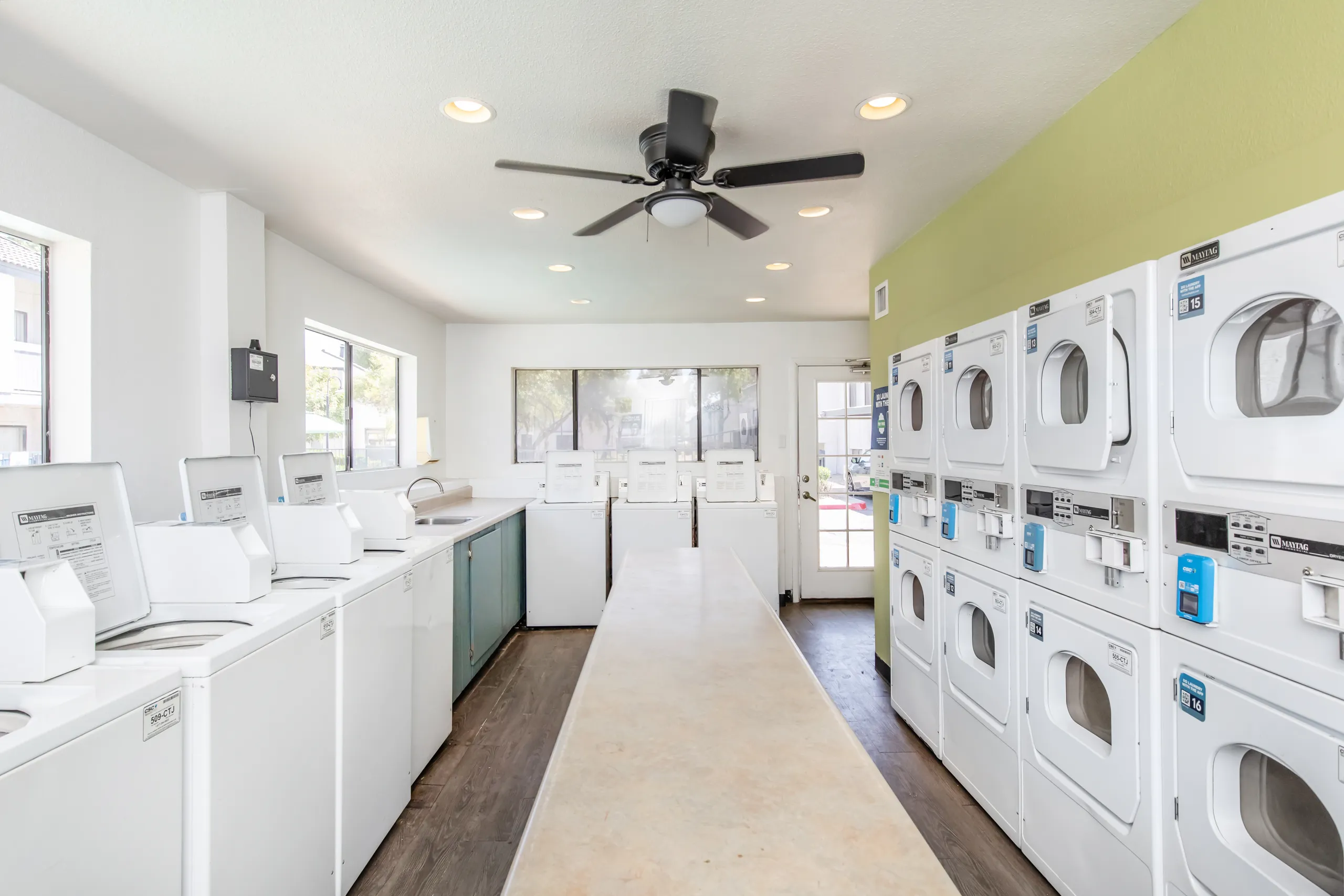 On-site laundry facility, stacked washers and dryers, folding counter