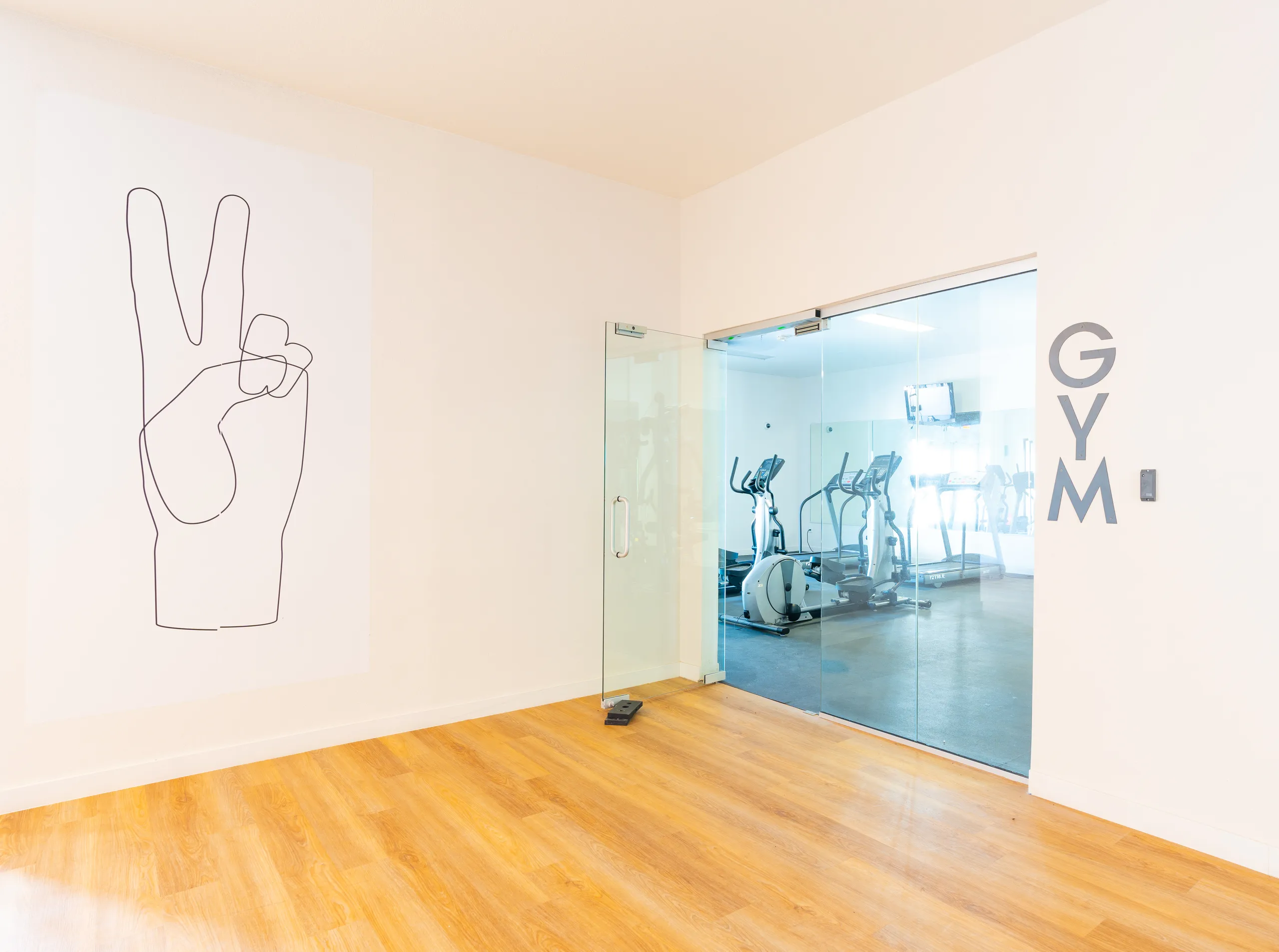 Glass gym entry door, wood-style flooring, wall graphic