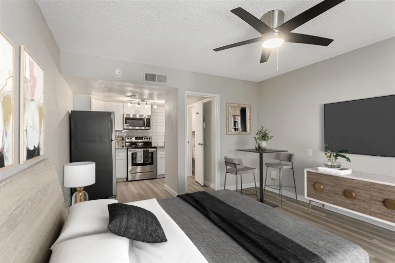 S1 Platinum studio layout, ceiling fan, view into kitchen, wood-style plank flooring