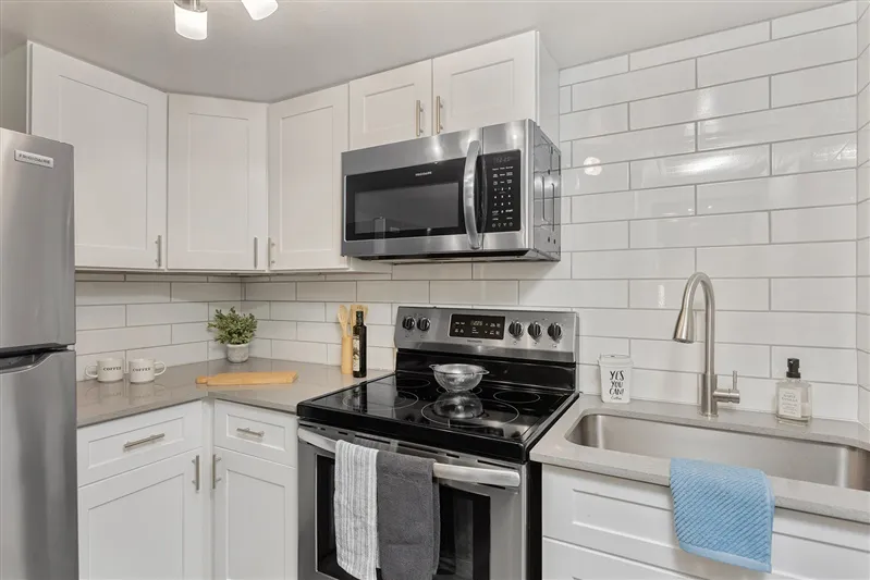 White cabinetry, stainless refrigerator, electric range, undermount sink