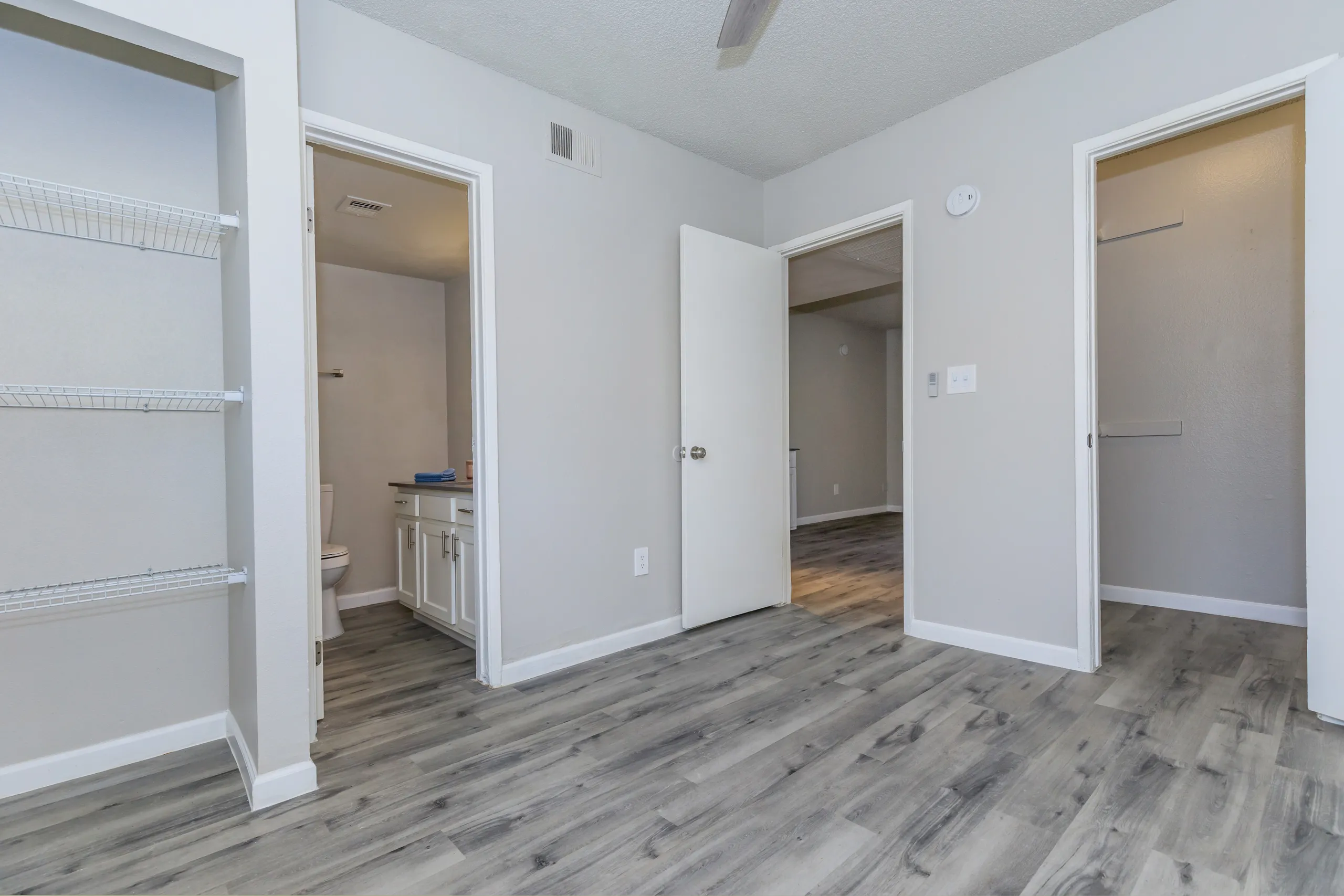 Bedroom with closet, en-suite bathroom entry, wood-style plank flooring