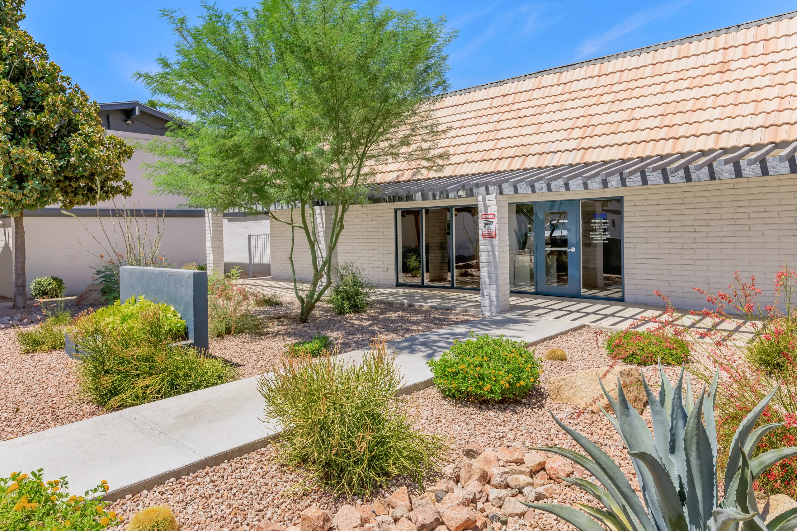 Office entrance, tile roof, desert landscaping, glass double doors