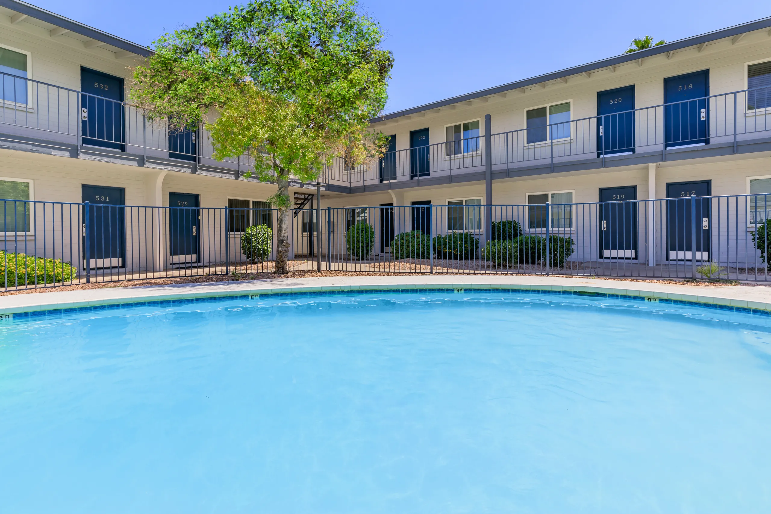 Courtyard pool, private balconies, palm tree, gated surround