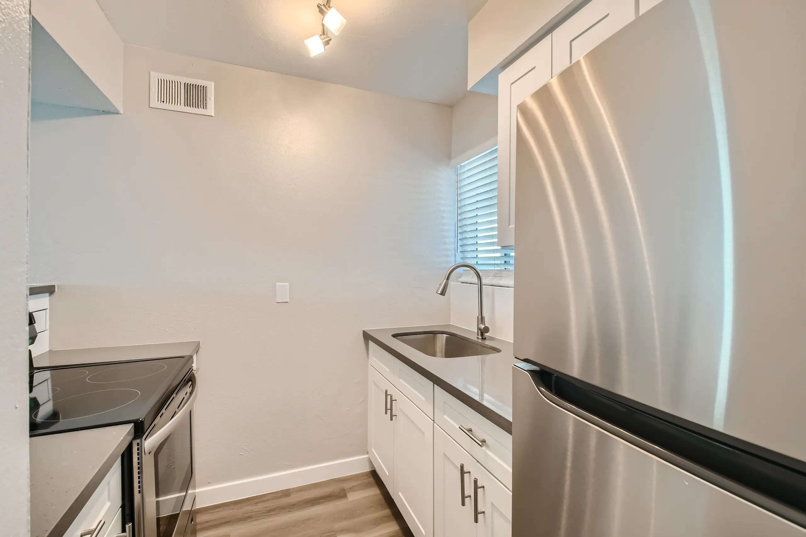 Stainless refrigerator, undermount sink, white cabinetry